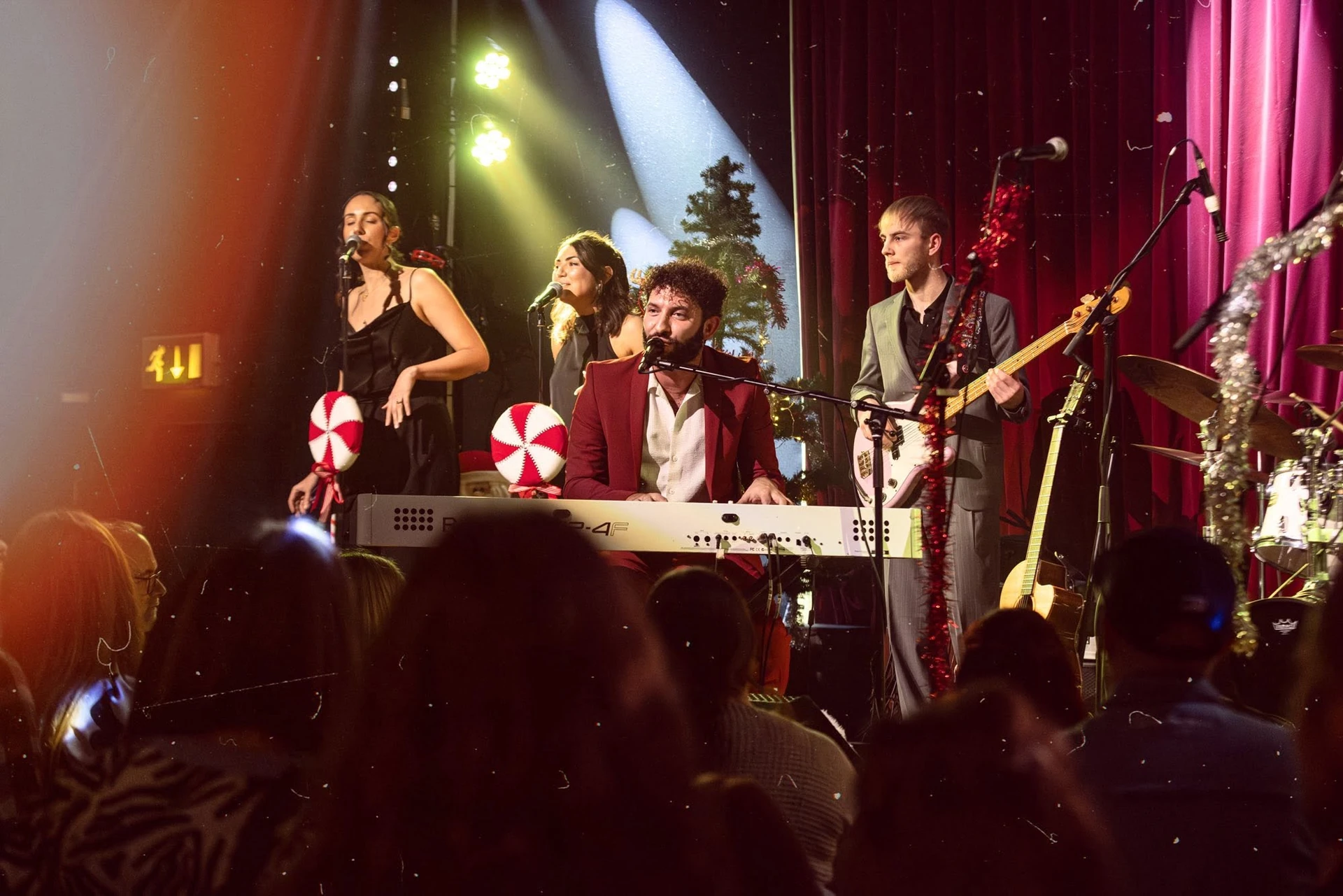 Billy Lockett performing at a piano with his band at a Christmas show