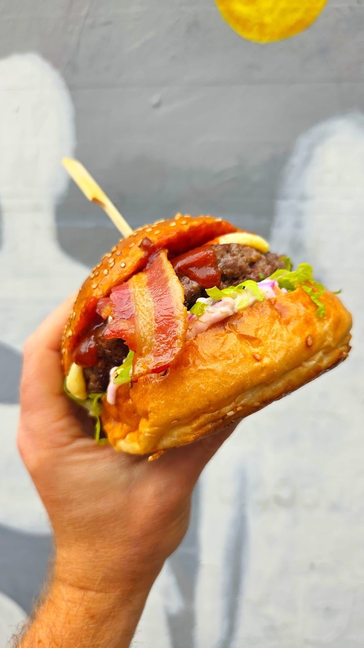 A freshly made burger with bacon, cheese and a sesame bun at The Charles Bradlaugh